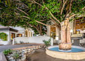 Thumbnail 3 of 48 - A statue of a woman stands in the middle of a fountain.