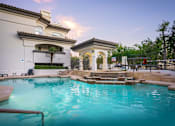 Thumbnail 7 of 48 - A swimming pool in a residential area with a building in the background.