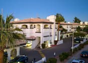 Thumbnail 11 of 48 - A large white building with a red tile roof and a palm tree in front.