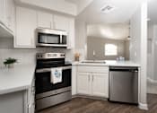 Thumbnail 22 of 48 - A modern kitchen with white cabinets and stainless steel appliances.