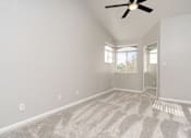 Thumbnail 28 of 48 - A room with a ceiling fan and carpeted floor.