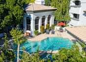 Thumbnail 33 of 48 - A pool surrounded by trees and a white building with columns.