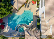 Thumbnail 34 of 48 - A swimming pool surrounded by a few trees and a house.