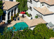 Thumbnail 38 of 48 - A white building with a pool in front of it.