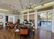 Thumbnail 19 of 25 - a large room with a large table and chairs and a pool in the background at 55+ Remington at Ladera Ranch, California, 92694
