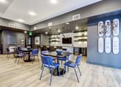 Thumbnail 10 of 18 - a dining room with blue chairs and tables and a kitchen
