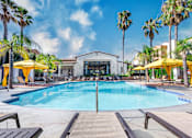 Thumbnail 2 of 80 - a swimming pool with yellow umbrellas and a white building in the background