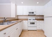Thumbnail 55 of 80 - a kitchen with white cabinets and white appliances