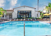 Thumbnail 6 of 80 - a resort style pool with chaise lounge chairs and a building in the background