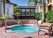 Thumbnail 3 of 80 - Hot tub with seating and building in the background