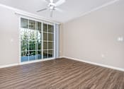 Thumbnail 42 of 80 - an empty living room with a sliding glass door and a ceiling fan