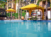 Thumbnail 4 of 80 - a swimming pool with a blue water and yellow umbrellas