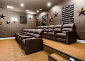 Thumbnail 24 of 80 - a cinema room with brown leather couches and chairs