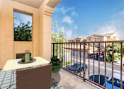Thumbnail 29 of 80 - a balcony with a table and chairs and a view of a parking lot