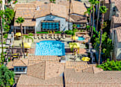 Thumbnail 76 of 80 - A large swimming pool surrounded by a tiled patio and palm trees.
