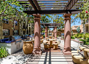 Thumbnail 77 of 80 - A patio with a table and chairs under a pergola.