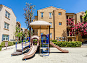 Thumbnail 78 of 80 - A playground with a brown slide and a blue and brown swing set.