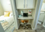 Thumbnail 19 of 97 - a small desk with a laptop and a desk chair in a room with a bed in model unit