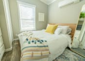 Thumbnail 20 of 97 - New Apartments In South Austin, TX - Casata Austin - Bedroom With High Ceilings, Wood-Inspired Plank Flooring, Bed, Dresser, Closet, Full-Length Mirror, AC Unit, And Window With Blinds