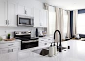 Thumbnail 10 of 50 - a kitchen with white cabinets and a white counter top