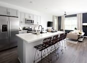 Thumbnail 17 of 50 - an open concept kitchen and living room with a large white island with a white countertop and