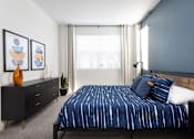Thumbnail 34 of 50 - a bedroom with a bed and dresser in a 555 waverly unit