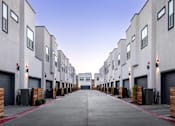 Thumbnail 44 of 50 - an empty street with rows of rental apartments