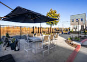 Thumbnail 48 of 50 - a patio with a table and chairs and an umbrella