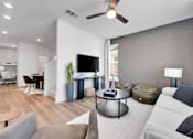 Thumbnail 116 of 149 - A modern living room with a grey sofa, a wooden coffee table, and a flat-screen TV.