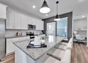 Thumbnail 112 of 149 - A modern kitchen with a granite countertop and stainless steel appliances.