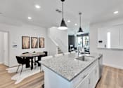 Thumbnail 118 of 149 - A modern kitchen with a dining table and chairs.