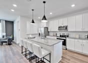 Thumbnail 120 of 149 - A modern kitchen with white cabinets and a central island.