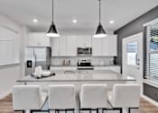 Thumbnail 115 of 149 - A modern kitchen with white cabinets and a central island.
