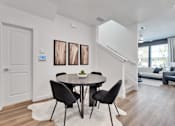 Thumbnail 103 of 149 - A modern dining room with a round table and chairs.