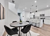 Thumbnail 113 of 149 - A modern kitchen with a dining table and chairs.