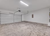 Thumbnail 122 of 149 - A large empty garage with a white door and a light on the ceiling.