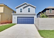 Thumbnail 110 of 149 - A house with a blue garage door is surrounded by a fence and other houses.