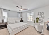 Thumbnail 114 of 149 - A bedroom with a large bed and a ceiling fan.