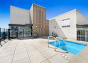 Thumbnail 31 of 117 - A modern building with a pool in front at Skyview Sunset Apartments, Los Angeles