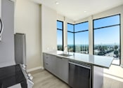 Thumbnail 51 of 117 - A modern kitchen with a large island and stainless steel appliances at Skyview Sunset Apartments, Los Angeles, CA