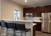 Thumbnail 21 of 57 - Kitchen with Wooden Cabinetry with Breakfast Bar with High Stools at Arboretum at South Mountain, Phoenix, 85044