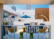 Thumbnail 9 of 89 - a balcony with a table and chairs and a fireplace with a blue sky in the background