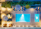 Thumbnail 16 of 89 - Pet-Friendly Apartments in South Park Los Angeles, CA - The Emerald - Aerial View of Pool, with Blue Lounge Chairs and Cabanas