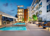 Thumbnail 19 of 89 - an outdoor swimming pool with chaise lounge chairs and a building in the background