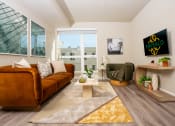 Thumbnail 21 of 89 - Apartments In South Park Los Angeles For Rent - Emerald - A Bright Living Space With A Fullsize Couch On One Wall And A Mounted TV On The Other Wall With Large Windows And Lightly Colored Walls