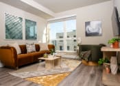 Thumbnail 22 of 89 - Apartments for Rent in Downtown Los Angeles, CA - The Emerald - Living Room with Floor-to-Ceiling Window, Abstract Coffee Table, and Luxury Plank Flooring