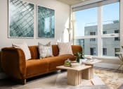 Thumbnail 23 of 89 - Apartments for Rent in Downtown Los Angeles, CA - The Emerald - Living Room with Floor-to-Ceiling Window, Abstract Coffee Table, and Luxury Plank Flooring