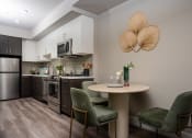 Thumbnail 34 of 89 - Apartments Near USC- Living Room With Open Floorplan, Kitchen View With Stainless-Steel Appliances, Wood-Style Floors, And Large Windows