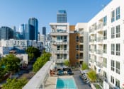 Thumbnail 40 of 89 - an aerial view of an apartment complex with a swimming pool and a city skyline in the background