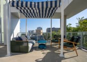 Thumbnail 47 of 89 - a pergola on a balcony with furniture and a view of the city
